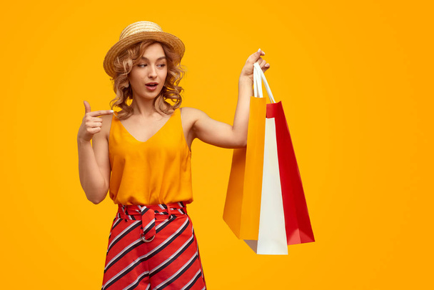 Trendy female pointing at shopping bags - Zdjęcie, obraz