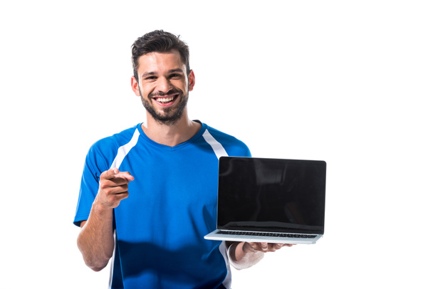 dizüstü bilgisayar ile mutlu futbol oyuncusu beyaz üzerinde Izole parmak ile işaret - Fotoğraf, Görsel