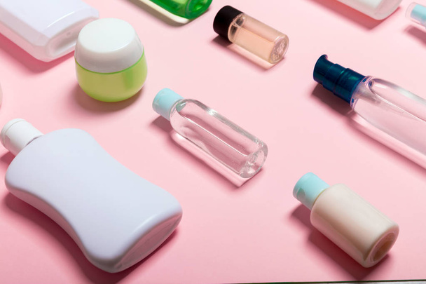 Pohled na kosmetické nádoby, rozprašovače, sklenice a láhve na růžovém pozadí. Zobrazení zavřením s prázdným místem pro návrh - Fotografie, Obrázek