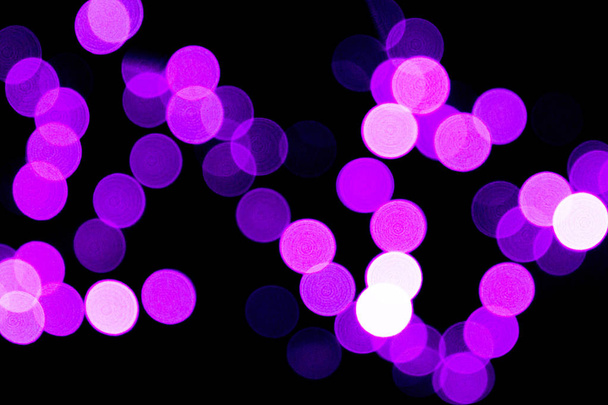 Unfocused abstract purple bokeh on black background. defocused and blurred many round light - Foto, imagen
