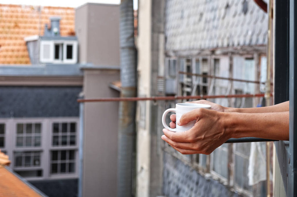joven tomando un café en el balcón
 - Foto, imagen