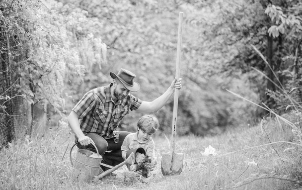 happy earth day. Family tree nursering. watering can, pot and shovel. Garden equipment. Eco farm. small boy child help father in farming. father and son in cowboy hat on ranch. Under the weather - Foto, Imagen