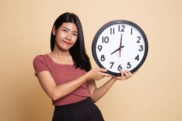 Young Asian woman with a clock. - Zdjęcie, obraz