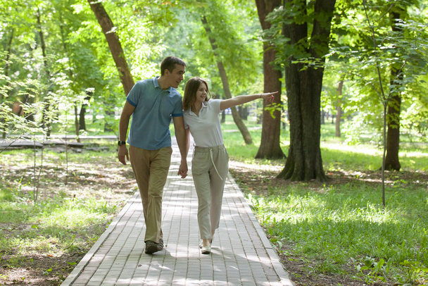 Pareja caminando de la mano en un parque - cita romántica al aire libre
 - Foto, imagen