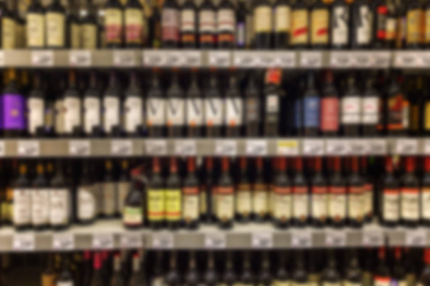 Assortment of wines on the supermarket shelves. The photo is blurry. - Foto, imagen