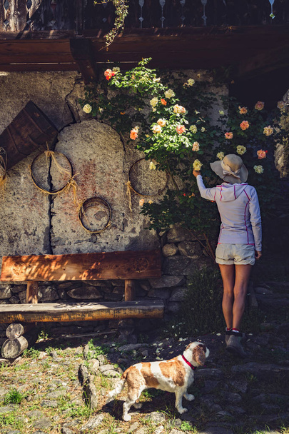 Chica vista por detrás mientras recoges una rosa
 - Foto, imagen