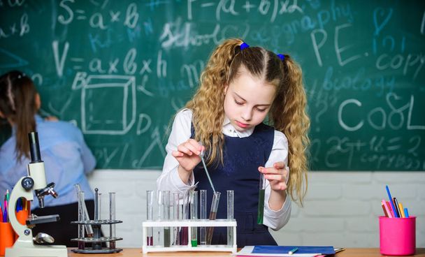 School pupil study chemical liquids. School chemistry lesson. Test tubes with substances. Future microbiologist. Laboratory glassware. School laboratory. Girl smart student conduct school experiment - Photo, image