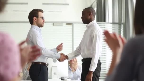 Happy african american male employee get rewarded handshake caucasian boss - Footage, Video