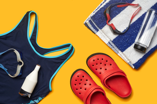 Flat lay accessoires de piscine d'été sur un fond jaune. Vêtements de plage colorés
. - Photo, image