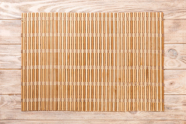 Pusta Asian Food Background. brązowy mat bambusa na drewnianym tle góry widok z kopią płaskiego lay - Zdjęcie, obraz