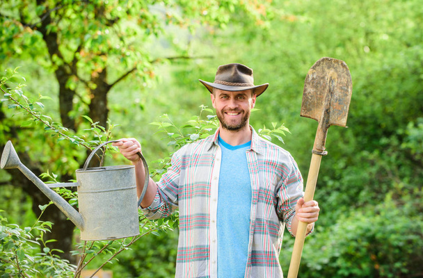 happy earth day. Eco living. Eco farm. Harvest. sexy farmer hold shovel and watering can. farming and agriculture. Garden equipment. muscular ranch man in cowboy hat. Taking good care of plants - Fotoğraf, Görsel