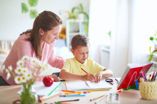 mother helps son to do lessons. home schooling, home lessons. th - Valokuva, kuva
