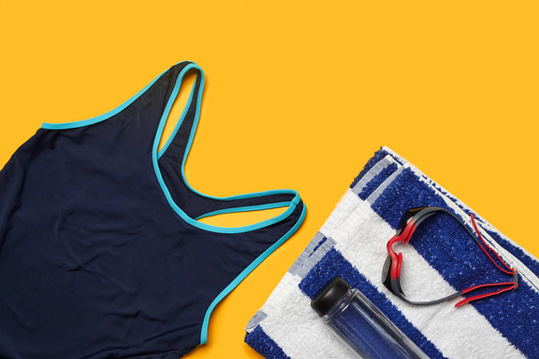 Flat lay summer pool accessories on a yellow background. Colorful beach wear. - 写真・画像