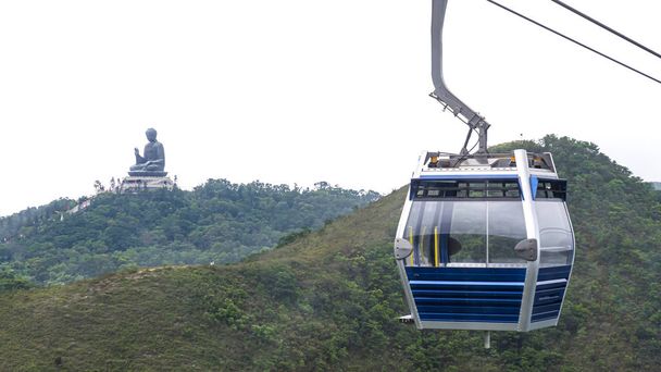 Hong Kong kabelbaan over groene berg met gigantische Boeddhabeeld - Foto, afbeelding