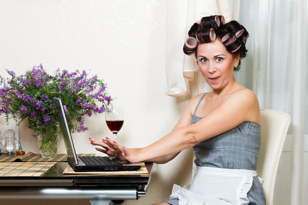 Домохозяйка в столовой с ноутбуком и красным вином
 - Фото, изображение