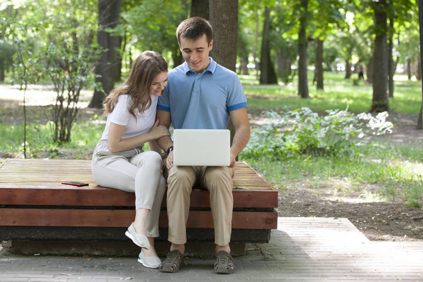 A guy and a girl are reading a book in a city park on a hot summer day. - Фото, зображення