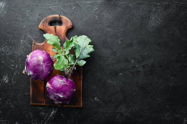 Purple kohlrabi cabbage. On a black stone background. Top view. Free space for your text. - Fotografie, Obrázek