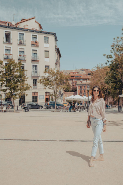 Full body portrait of beautiful young tourist woman visiting the city of Madrid, Spain. Girl posing on the street. - 写真・画像
