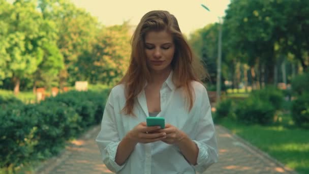 close up νεαρή γυναίκα περπάτημα συνομιλία με το τηλέφωνο - Πλάνα, βίντεο