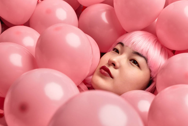 Pink balloons on Asian female - Фото, изображение