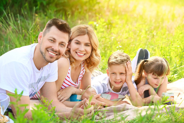Счастливая семья на летнем пикнике в парке
 - Фото, изображение