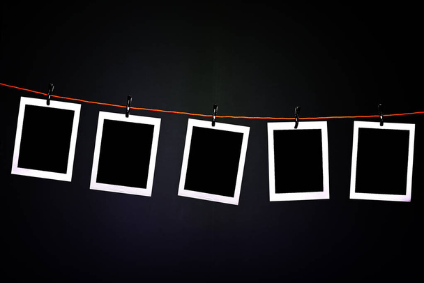 Fotografías Polaroid en blanco colgando de una cuerda en el cuarto oscuro de la fotografía
 - Foto, Imagen