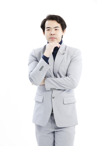 Portrait of handsome young thoughtful businessman isolated over white background - 写真・画像