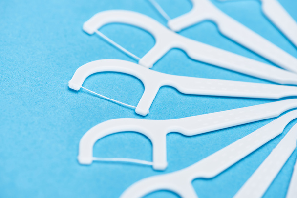 selective focus of white floss sticks isolated on blue  - Photo, Image