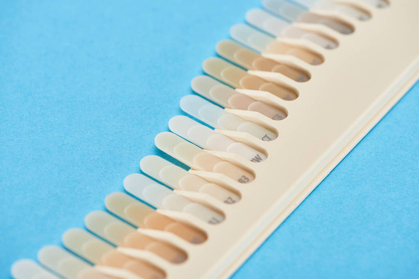 selective focus of teeth samples with different shades isolated on blue  - Photo, Image