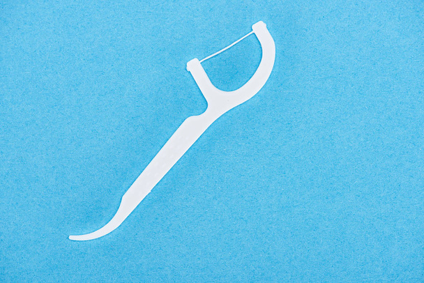 top view of white and plastic floss toothpick isolated on blue  - Photo, Image