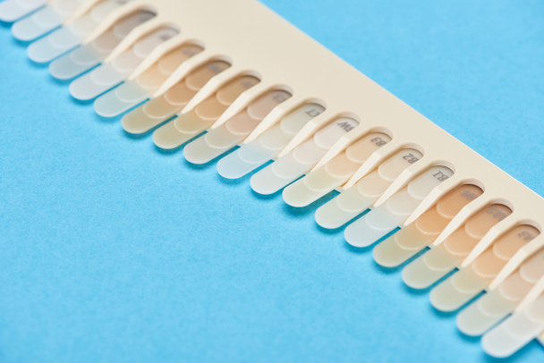mise au point sélective de la palette de dents avec différentes nuances isolées sur le bleu
  - Photo, image