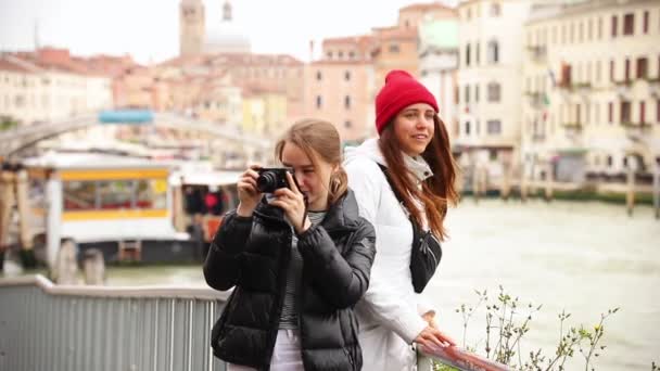 Dos mujeres jóvenes en las calles de Venecia. Uno de ellos toma una foto de los alrededores
 - Imágenes, Vídeo