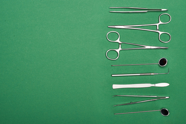 top view of set with dental tools and scissors isolated on green  - Foto, afbeelding