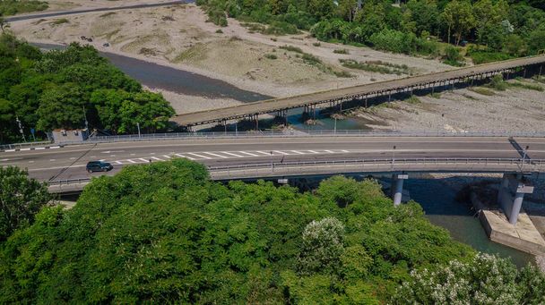 Воздушный обзор движения на мосту, 2 полосы дороги с автомобилями
 - Фото, изображение