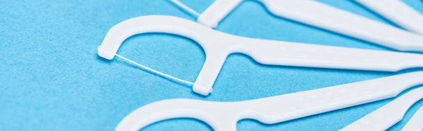 tiro panorâmico de varas de fio dental branco isolado em azul
  - Foto, Imagem