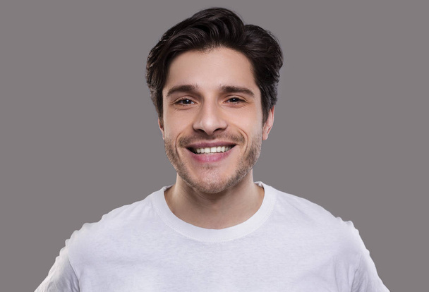 Όμορφος νέος Καυκάσιος άνθρωπος χαμογελά στην κάμερα - Φωτογραφία, εικόνα
