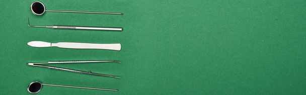 plano panorámico de conjunto con herramientas dentales y tijeras aisladas en verde
  - Foto, imagen