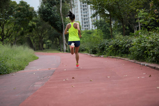 Fitness urheilullinen nainen lenkkeilijä käynnissä lenkkeily radalla puistossa
 - Valokuva, kuva