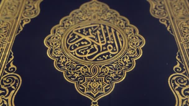 Quran blauwe cover versierd met gouden woorden betekenen "Heilige Qur'An", ondiepe scherptediepte van veld close-up slow Tilt up CGI shot. - Video