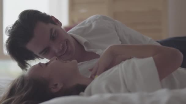 Man and woman laying on bed laughing. Concept of happiness and tenderness. Couple in love. - Felvétel, videó