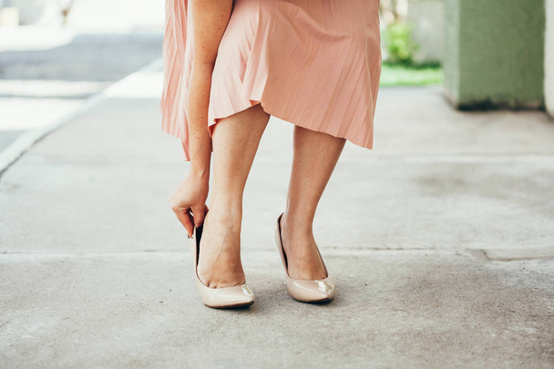 Женщина, страдающая от боли в ногах на улице из-за неудобств
  - Фото, изображение