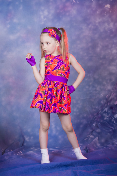Pieni tyttö tanssii värikkäässä asussa
 - Valokuva, kuva