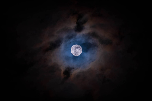 Lua cheia com nuvens fundo preto detalhe superfície
 - Foto, Imagem