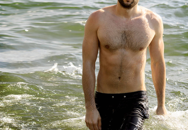 Handsome topless man body in sea water - Photo, image