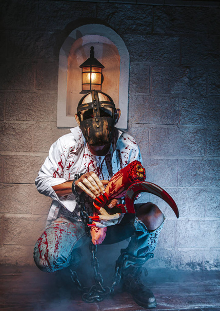 costume d'Halloween, homme enchaîné avec du sang et un couteau, homme zombie mort l'horreur fantôme drainer la peau de sang de la main crie obscurité et fond de cauchemar de peur effrayante sur l'enfer est monstre diable dans le concept de festival d'Halloween
 - Photo, image