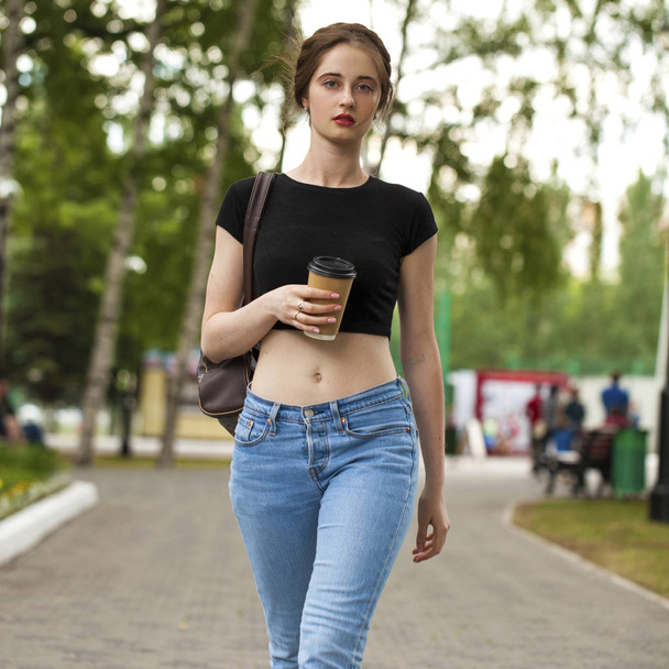 Young beautiful brunette girl in jeans and t-shirt walking in su - Foto, afbeelding