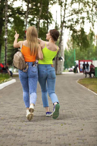 Two girlfriends walking on summer park, outdoors - Foto, imagen