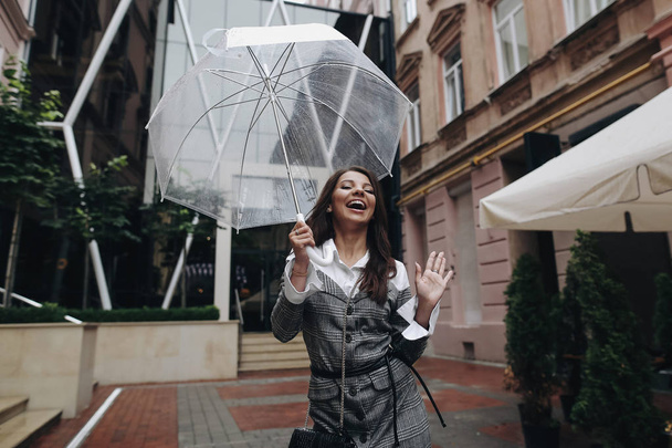 Πορτρέτο ενός γελώντας ευτυχισμένη γυναίκα με ομπρέλα κοντά στο καφέ.  - Φωτογραφία, εικόνα