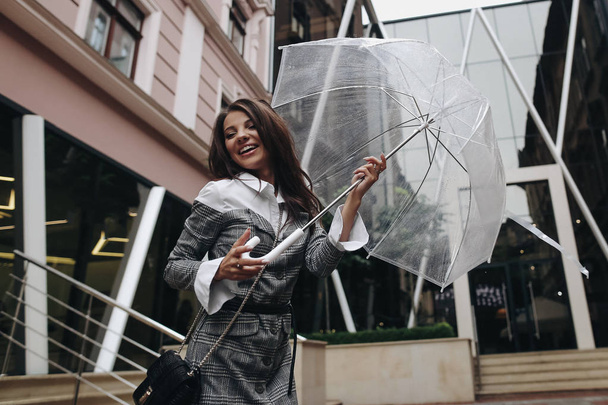 Портрет веселої смішної жінки, що позує з парасолькою поруч
  - Фото, зображення