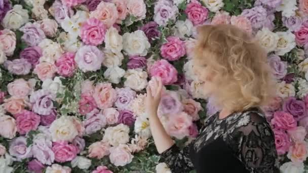 Kobieta spacery wzdłuż kwiatów - Materiał filmowy, wideo
